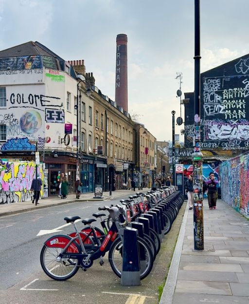 Brick Lane in East London with vibrant street art and the Truman Brewery chimney