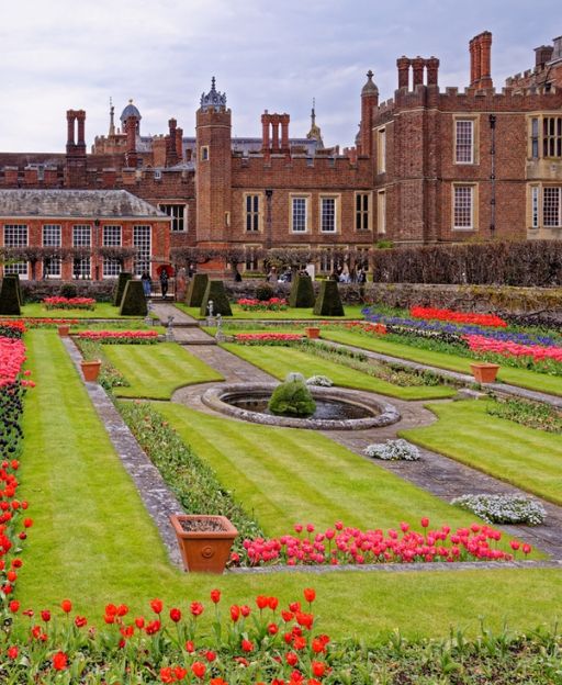 Hampton Court Palace formal gardens with red and pink tulips in full spring bloom