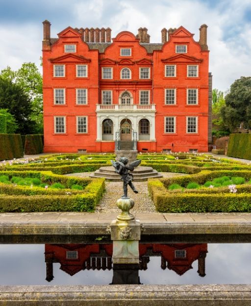Kew Palace, the historic red-brick Georgian royal residence reflected in a formal garden pool in London