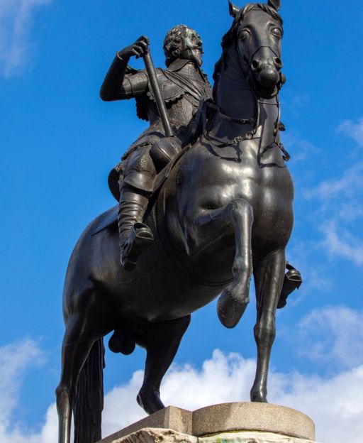 Equestrian statue of King Charles I in Trafalgar Square, London, with blue sky background