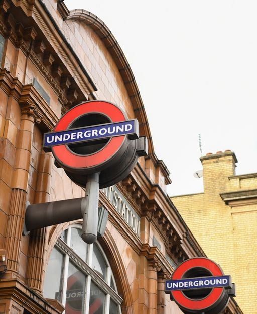 Earl’s Court Underground Station entrance with iconic red roundels on Victorian brick facade