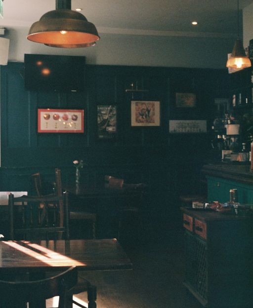 Traditional London pub interior with teal walls and wooden tables