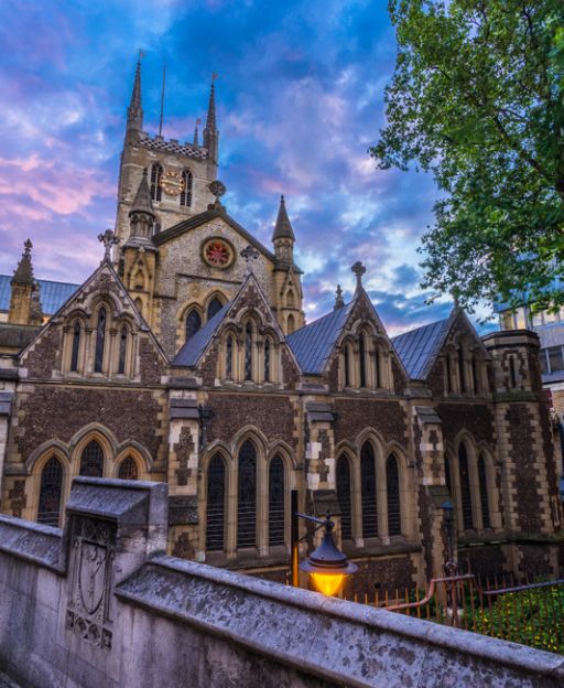 Southwark Cathedral at dusk, Gothic towers rising against a purple sky beside London Bridge