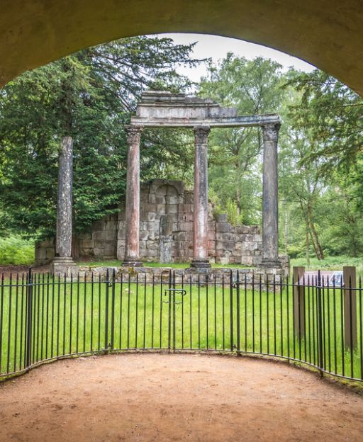 Ancient Roman columns at Virginia Water, Windsor Great Park, framed by a stone arch