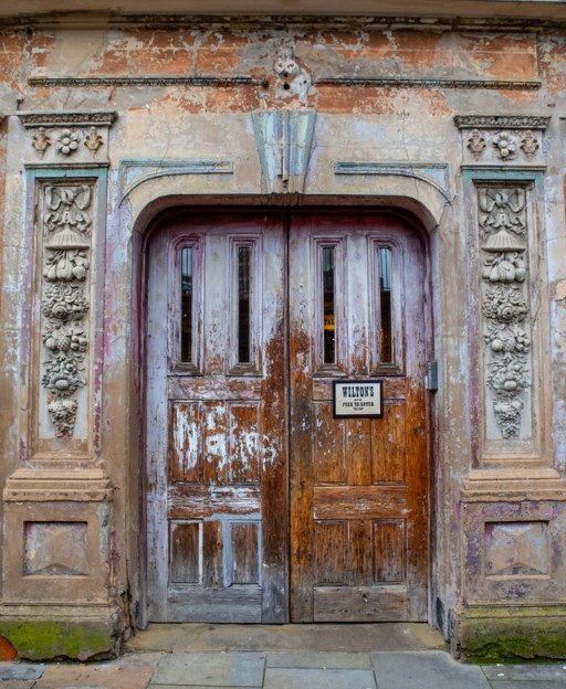 The ornate Victorian doorway of Wilton's Music Hall in Whitechapel, East London, with peeling paint and carved stone details