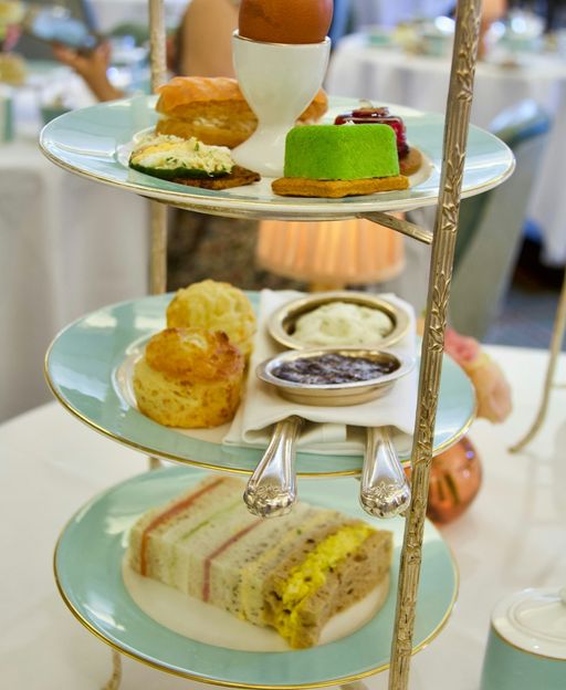 Three-tiered afternoon tea stand with finger sandwiches, scones and pastries at a London hotel
