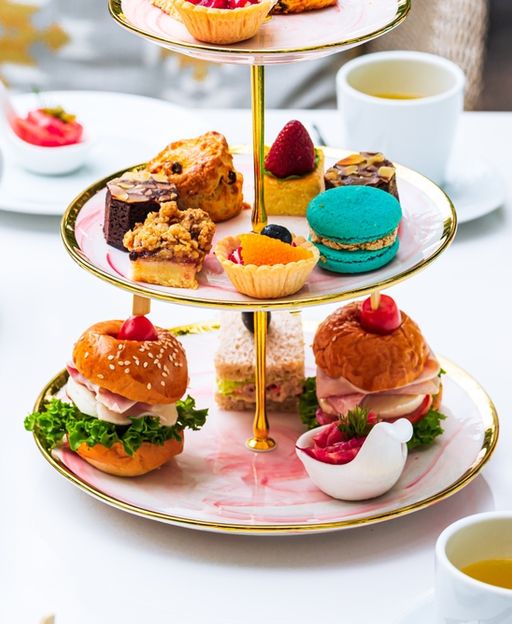 A beautiful afternoon tea spread with finger sandwiches, scones, and pastries on a tiered cake stand