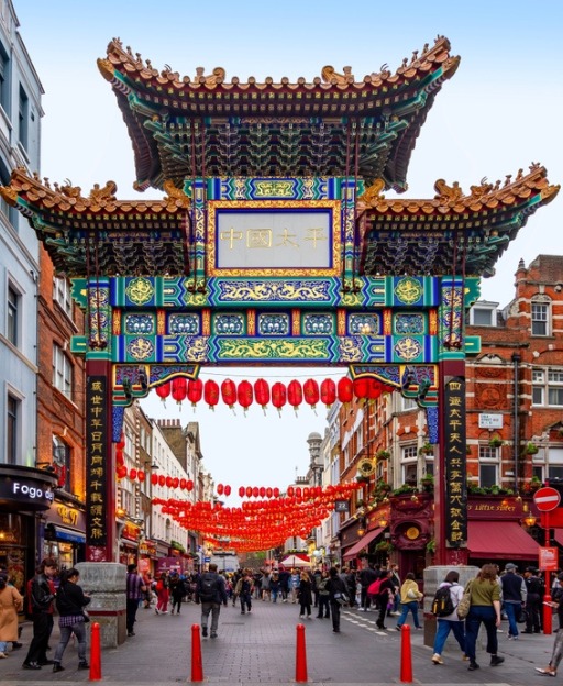 The ornate red and gold gate of London's Chinatown on Wardour Street, decorated with red lanterns