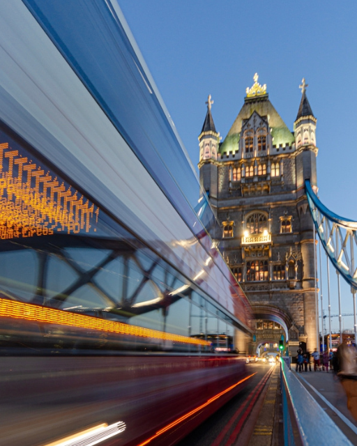 Tower Bridge lit up at night with light trails from passing traffic on the River Thames
