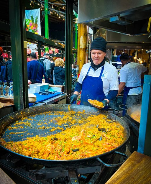 Street food chef serving paella at Borough Market, one of London's best street markets