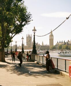 Visitors walking along the South Bank riverside path in London with the Thames in view