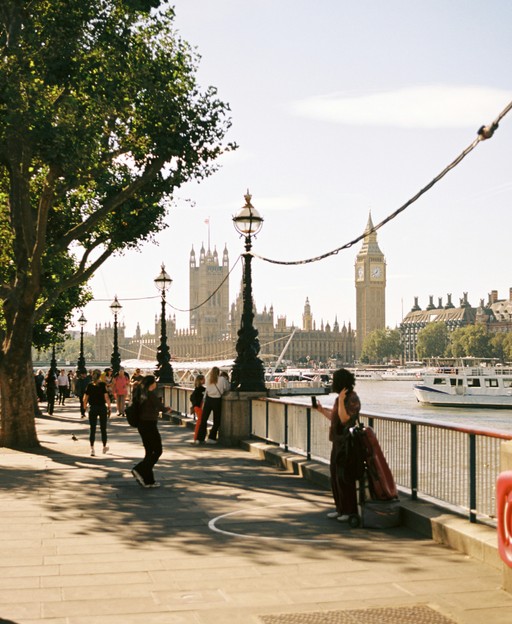 Visitors walking along the South Bank riverside path in London with the Thames in view