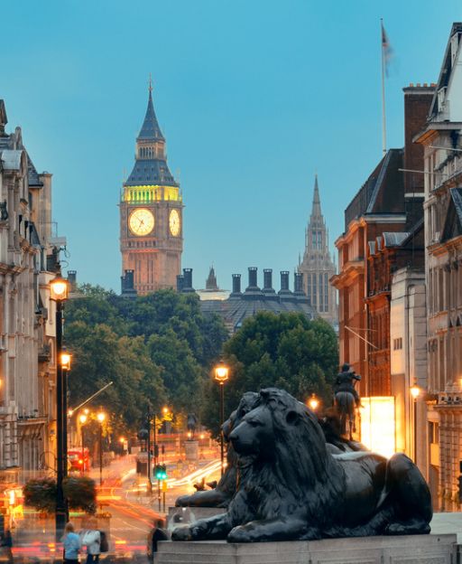 Trafalgar Square at night with Big Ben lit up in the background, London