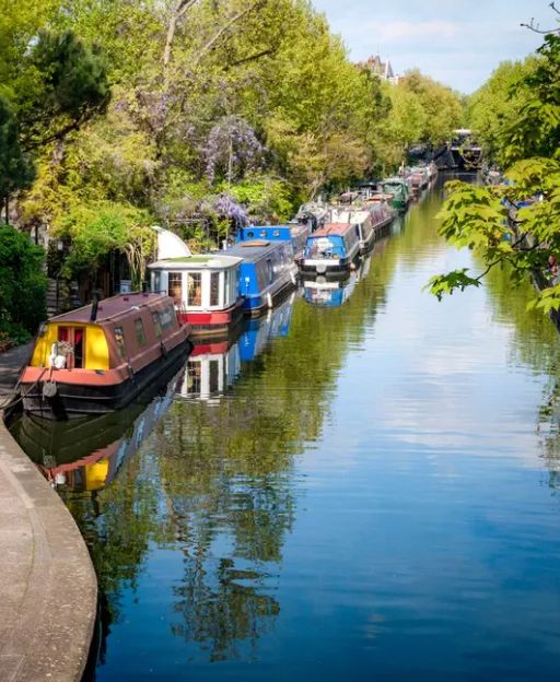 Little Venice canal in London with colourful narrowboats and tree-lined towpaths