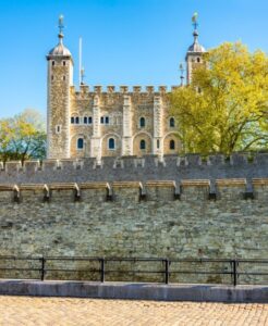 The White Tower at the Tower of London, with its pale stone walls and turrets against a blue sky