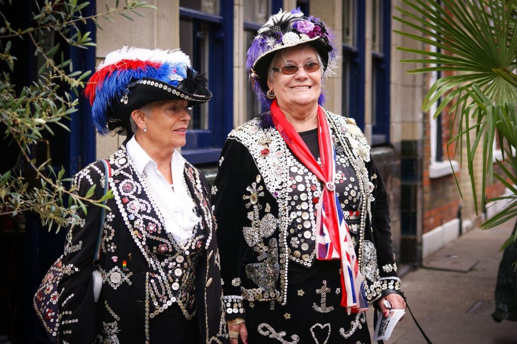 A Pearly King and Queen in their button-covered suits on a London street