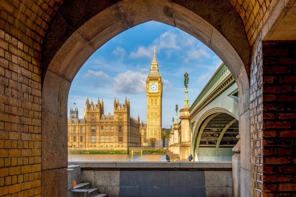 Big Ben framed by a brick arch beside Westminster Bridge, London