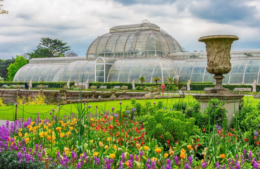 The glass Palm House behind spring flower beds at Kew Gardens