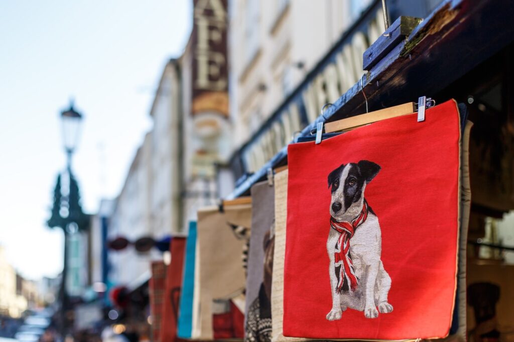 A stall hung with printed cushion covers on Portobello Road, London