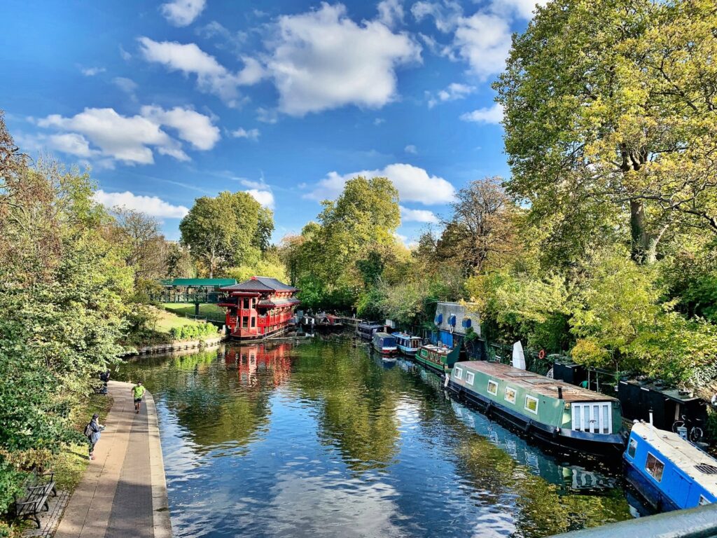 Narrowboats moored along the tree-lined Regent's Canal by Regent's Park, London