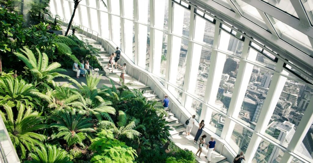 Visitors walking among ferns and palms inside the Sky Garden at the top of 20 Fenchurch Street, London