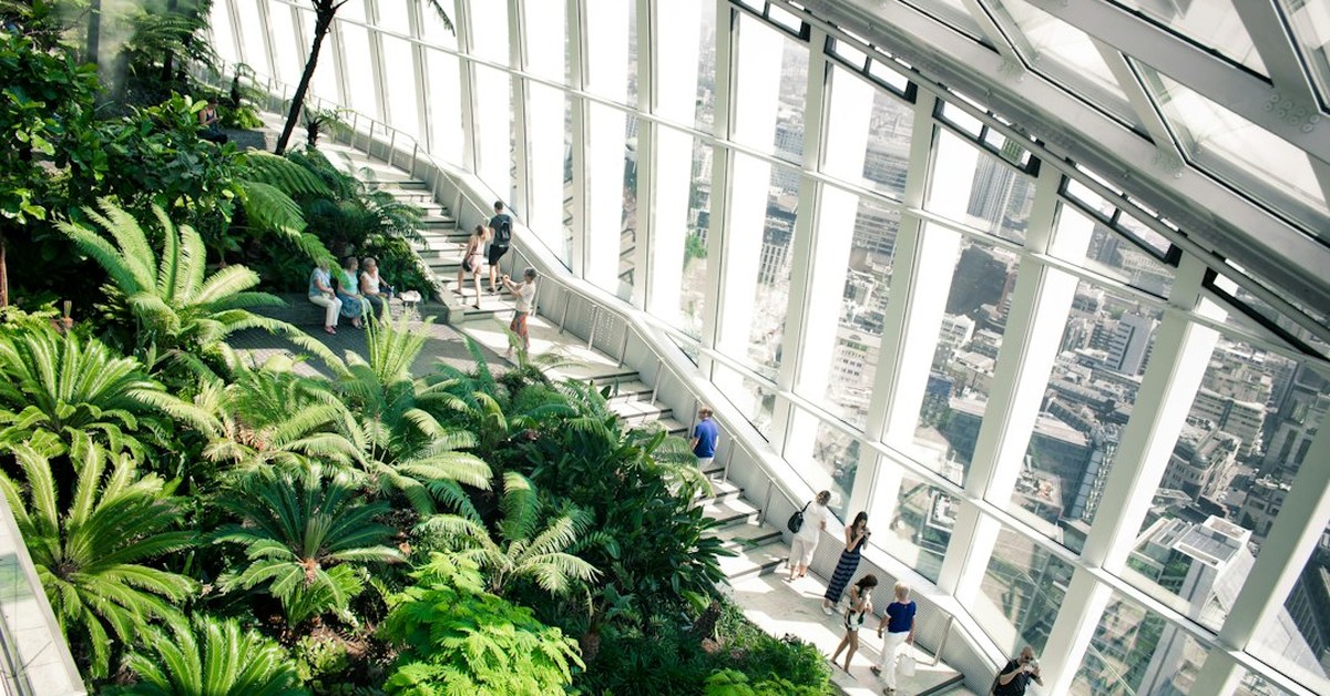 Visitors walking among ferns and palms inside the Sky Garden at the top of 20 Fenchurch Street, London