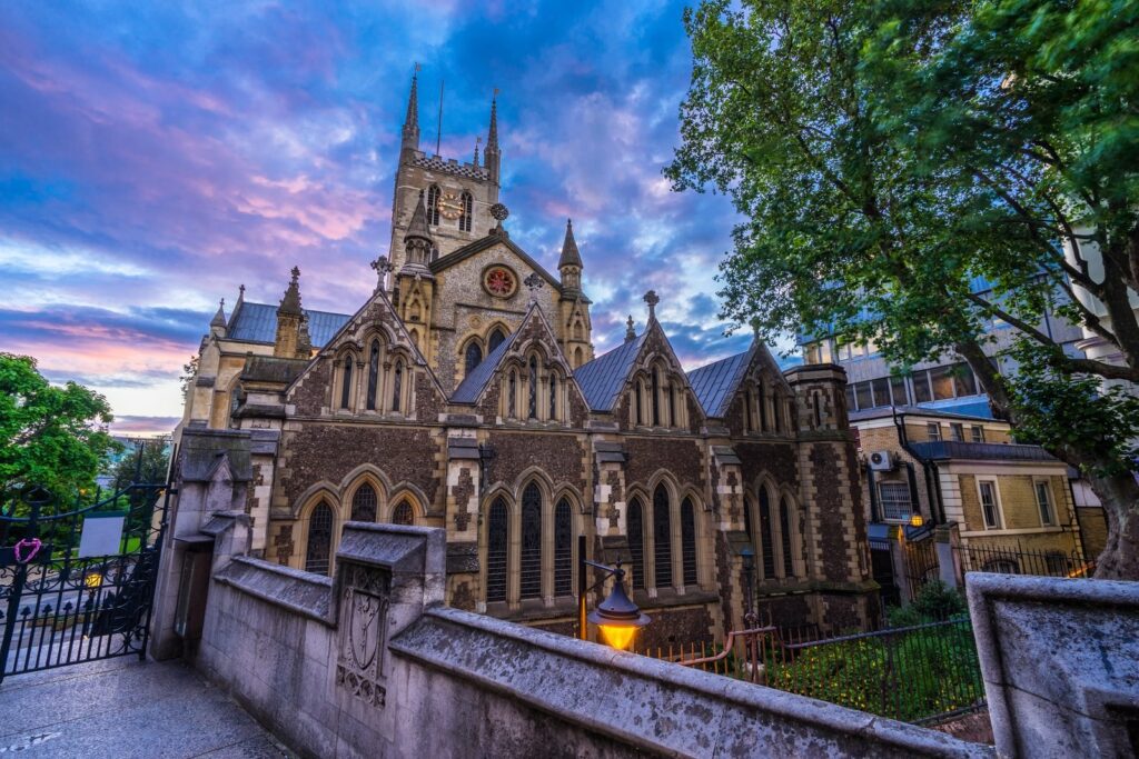 Southwark Cathedral at dusk, Gothic towers rising against a purple sky beside London Bridge