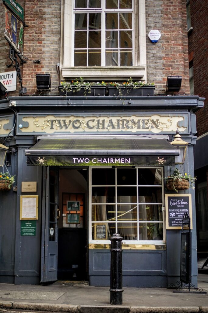 Front of the Two Chairmen, a traditional London pub with a painted sign and brick upper floor
