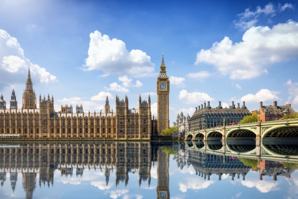 Houses of Parliament and Westminster Bridge reflected in the Thames under a summer sky